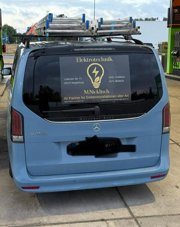 Firmenfahrzeug mit Aufkleber der Firmendaten und Logo mit Glühlampe und Blatt